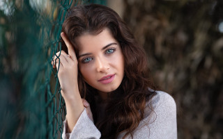 Woman fence serious blueeyes longhair - a woman leaning against a fence free wallpaper
