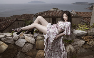 Woman dress rock wall ocean - a view of the ocean in the background free wallpaper