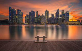 City skyline sunset pier bench - a red sky in the background free wallpaper