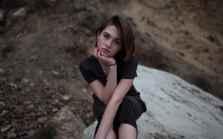 Woman sitting rock serious portrait - her chin free wallpaper for desktop