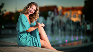 Woman sitting fountain smiling portrait - a ledge in front free wallpaper