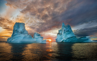 Iceberg sunset ocean clouds mountain - a sun setting behind free wallpaper