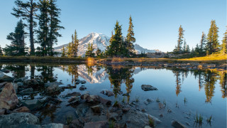 Mountain lake reflection rocks trees - a clear blue sky in the background free wallpaper
