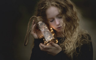Girl holding glass ball lights - a string of lights free wallpaper