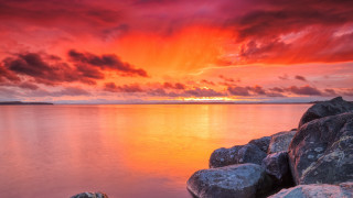 Sunset water rocks red sky - a red sky in the background free wallpaper