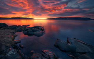 Sunset rocks mountain water red - the foreground and a mountain in the background free wallpaper