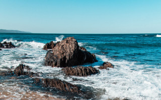 Rocky shore waves boat sky - ocean free wallpaper for desktop