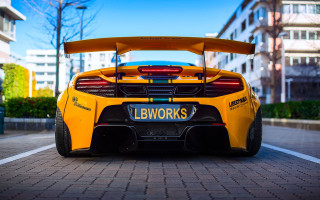Yellow sports car brick road - tall building free wallpaper for desktop