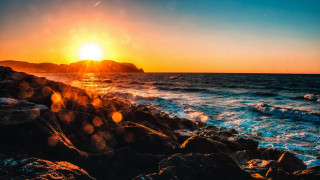 Sunset ocean rocks water mountain - a sunset over the ocean free wallpaper