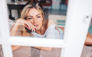 Woman couch window hand chin - her cheek free wallpaper