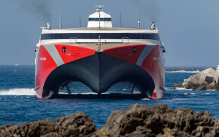 Large boat rocks outcropping beach - face free wallpaper