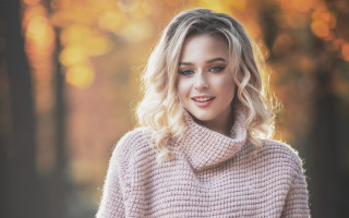 Blonde woman pink sweater smiling - a pink sweater free wallpaper