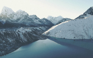 Mountain range lake snowy mountains - a lake in the middle of it free wallpaper