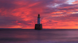 Lighthouse water cloudy sunset mountain - water under a cloudy sky free wallpaper