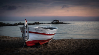 Beach sunset boat water mountain - a sunset in the background and a body of water free wallpaper for desktop