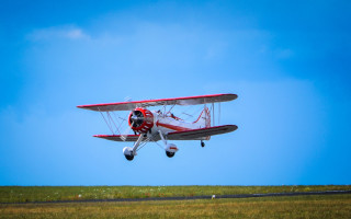 Red white plane flying grass - motion blur free wallpaper