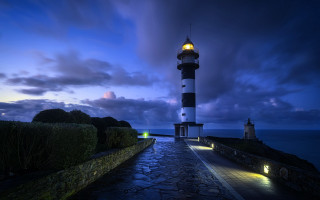 Lighthouse rocky shore night city - atmospheric free wallpaper