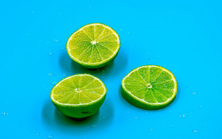 Three limes water droplets blue - a blue surface free wallpaper
