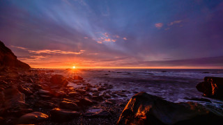 Sunset rocky beach water shore - a sunset over a rocky beach free wallpaper