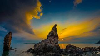 Rock formation ocean sunset clouds - a rock formation in the ocean free wallpaper