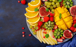 Plate fruit orange grapes kiwi - a blue table free wallpaper
