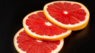 Grapefruit slices black background food - cut free wallpaper