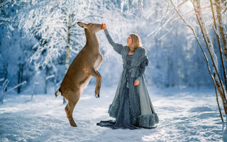 Woman feeding deer snow forest - a long dress free wallpaper