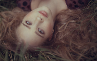 Woman lying grass blowing hair - the wind free wallpaper