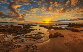 Sunset rocky beach water clouds 4 - a sunset over a rocky beach free wallpaper