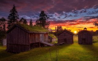 Sunset grassy field wooden buildings - allan linder free wallpaper