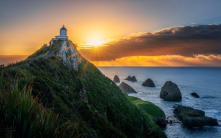 Lighthouse hill sunset ocean grassy - the sun setting behind free wallpaper for desktop