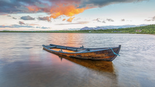 Lake mountains boat sunset cloudy - top of a lake under a cloudy sky free wallpaper