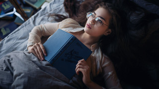 Woman lying reading book ankazhuravleva - a bed holding free wallpaper