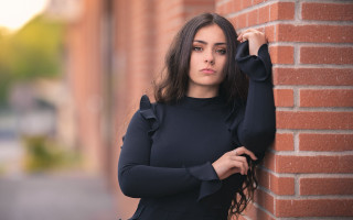 Elina karimova brick wall portrait 2 - a woman leaning against a brick wall free wallpaper