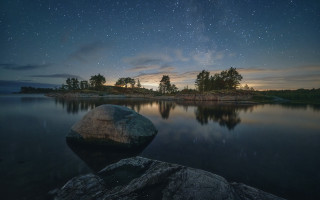 Lake rock starry night sky - a rock in the middle of it free wallpaper