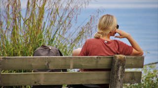 Woman bench water backpack ocean - a view of the ocean in the background free wallpaper