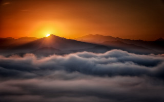 Sunset mountain range clouds sunshine - a sunset over a mountain range free wallpaper