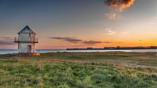 Lighthouse grassy field ocean sunset - a lighthouse free wallpaper