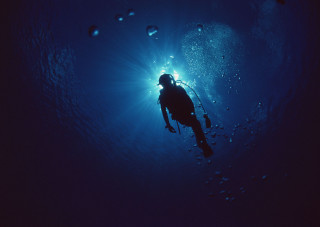 Scuba diver swimming light bubbles - a light shining free wallpaper