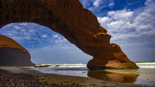 Large rock formation beach sky - a large rock formation free wallpaper