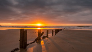 Sunset beach wooden fence dusk - a sunset over a beach free wallpaper