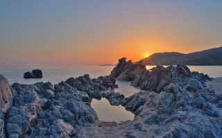 Sunset rocky beach mountains pool - a sunset over a rocky beach free wallpaper