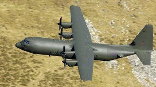 Military plane flying over grass - a large military plane free wallpaper