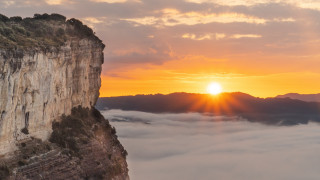 Mountain cliff sunset clouds foreground - cloud below free wallpaper
