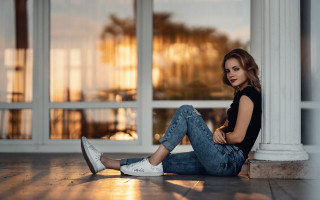 Woman sitting building blue eyes - a window behind her free wallpaper