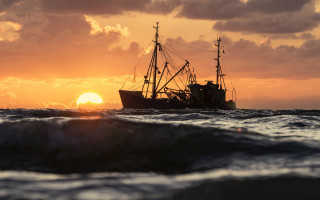 Sunset ocean boat cloudy sky - a sun setting behind free wallpaper