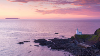 Lighthouse rocky cliff ocean sunset 12 - a small island in the distance free wallpaper