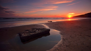 Rock beach sunset ocean sky - orange sun free wallpaper
