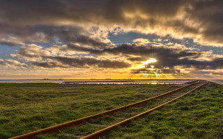 Train track grassy field sunset - the sun setting behind free wallpaper