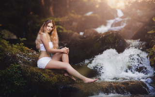 Woman sitting by waterfall forest - a rock next free wallpaper
